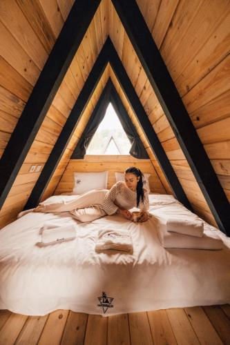 a woman sitting on a bed in a attic at Palm Bungalov Hotel in Kartepe