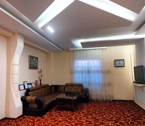 uma sala de estar com um sofá e uma televisão em NUKUS GUEST HOUSE em Nukus