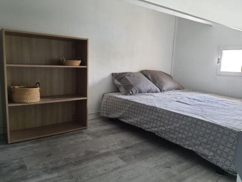 - une chambre avec un lit et une étagère dans l'établissement A 500 m de la plage, tout confort avec wifi, au Barcarès