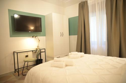 a bedroom with a bed with a desk and a television at B&b Apartment 1970 in Lauria