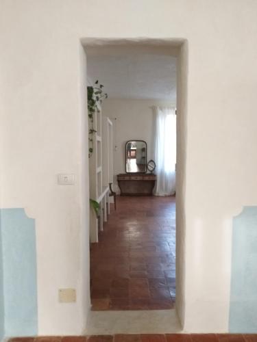 a hallway with white walls and a stairway with a mirror at Villa Amai in Bene Vagienna