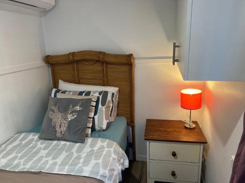 um quarto com uma cama e uma mesa com um candeeiro em XYL Pets Friendly Opened Spacious Seaside Boutique Guesthouse em Caloundra