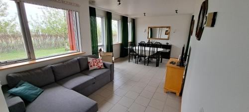 a living room with a couch and a table at Ægisholt privete house with hot tub in Patreksfjörður