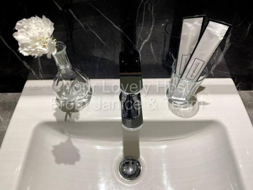 a sink with a wine bottle and two glasses at #4 KLCC Platinum Suites (Face Suites) 1BED 1BATH in Kuala Lumpur