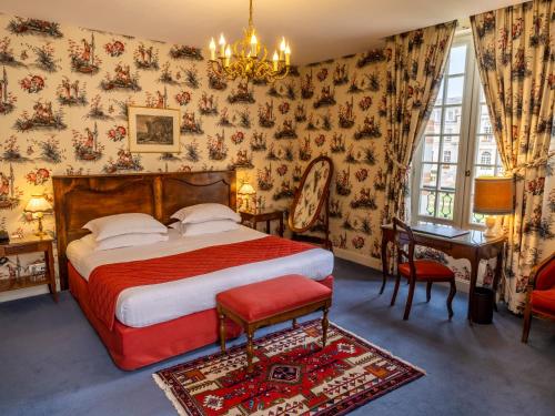1 dormitorio con cama y lámpara de araña en Château D'artigny, en Montbazon