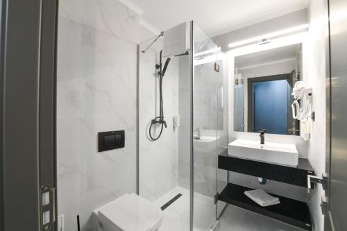 a bathroom with a shower and a toilet and a sink at HOTEL TOPAZ 4* CAP AURORA in Cap Aurora