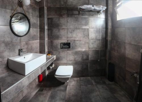 y baño con aseo, lavabo y espejo. en KATRINA HOTEL, en Skaramangás
