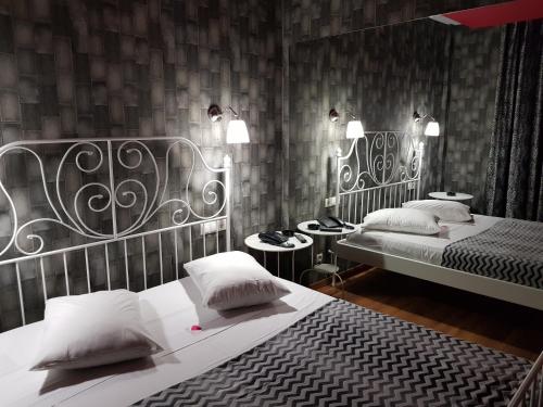1 dormitorio con 2 camas individuales y 2 mesas en KATRINA HOTEL, en Skaramangás