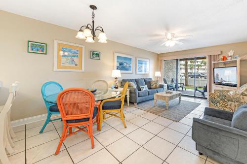 a living room with a table and chairs at Seaside Beach & Racquet 2105 in Orange Beach