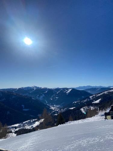 a person sitting on top of a snow covered mountain at Appartment Rosennock in Sankt Oswald