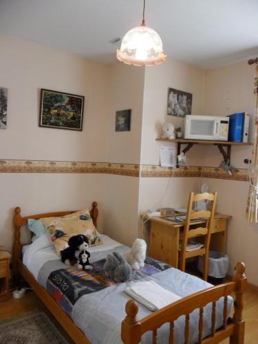une chambre avec un lit avec des animaux en peluche dessus dans l'établissement Chambre chez l'habitant, à Louvres