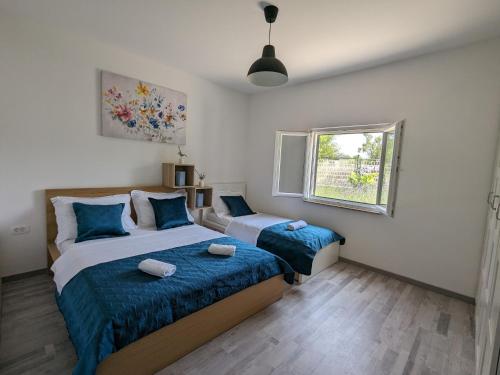 a bedroom with two beds and a window at Runaway Cottage in Unešić