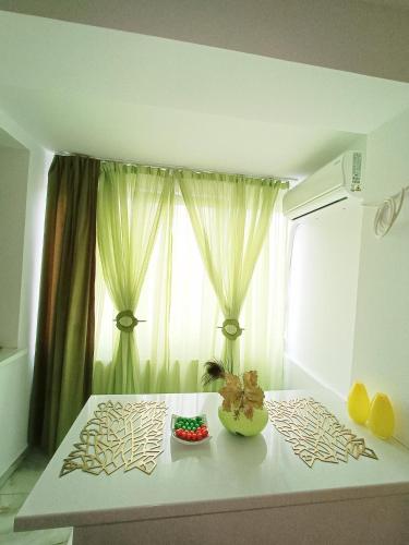 Zimmer mit einem Fenster und einem Tisch mit Blumen in der Unterkunft Garsoniera miky in Deva