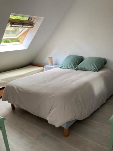 une chambre avec un grand lit avec des oreillers verts dans l'établissement Appartement dans maison de campagne au calme, à La Trinité-sur-Mer