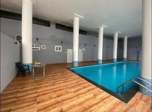 uma grande piscina num edifício com piso de madeira em The Dejà View em Rājpur