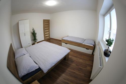 a small bedroom with two beds and a window at Dom Marhuľa in Štúrovo