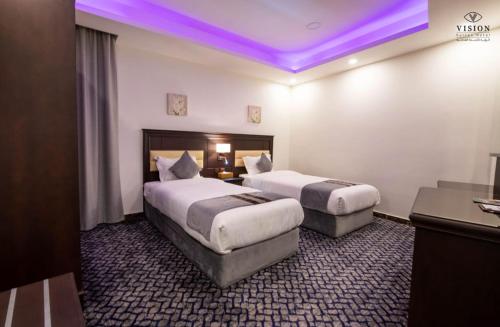 - 2 lits dans une chambre d'hôtel avec éclairage violet dans l'établissement فندق الرؤية محافظة الداير بني مالك, à Al Buhrah