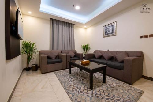 a living room with two couches and a table at فندق الرؤية محافظة الداير بني مالك in Al Buhrah