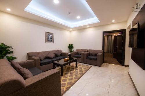 un soggiorno con divani, divano e tavolo di فندق الرؤية محافظة الداير بني مالك a Al Buhrah