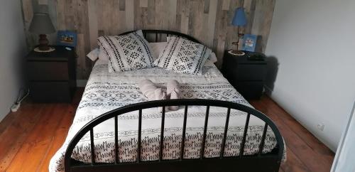een bed met zwarte en witte lakens en kussens bij Petite maison de vacances in Pléneuf-Val-André