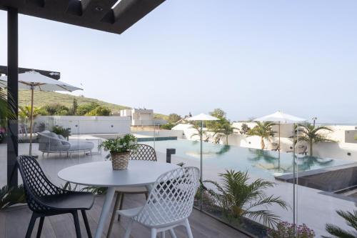 a patio with a table and chairs and a pool at Alaia Resort- Had Nes אלאיה ריזורט - חד נס in Had Nes