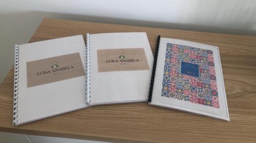 two open notebooks sitting on a table at Vila Luisa Anabela Piscine et Jacuzzi only family in Albufeira