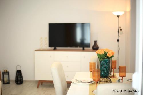 a living room with a table with a television on a cabinet at ULO Residence in Alba Iulia