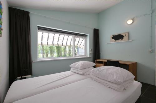 デン・ヘルダーにあるPakhuys Lodge - Oudのベッドルーム1室(白いシーツ付きのベッド1台、窓付)