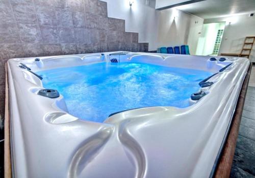 a large bath tub with blue water in it at Czerwone Wierchy & Spa in Zakopane