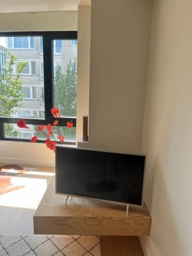 a flat screen tv in a living room with a window at beau soleil oostende in Ostend