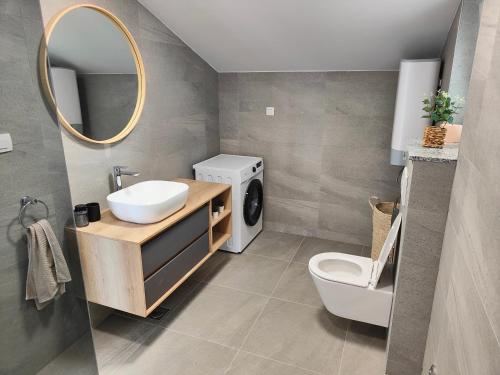 a bathroom with a sink and a washing machine at Eva Apartment 2 in Trogir