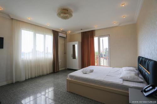 1 dormitorio con cama y ventana grande en Hotel CARLEONE en Batumi