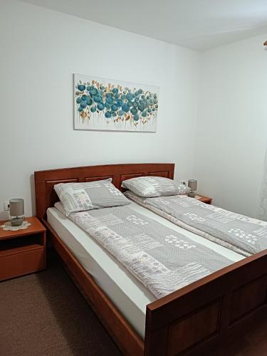 a bed in a bedroom with a picture on the wall at Apartment Hinic in Vrhovine