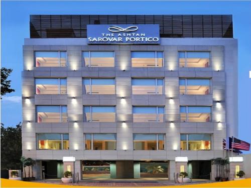 a building with a sign on top of it at The Ashtan Sarovar Portico in New Delhi