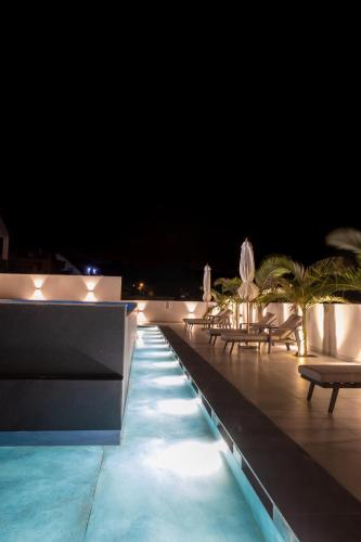 a swimming pool at night with chairs and umbrellas at Alaia Resort- Had Nes אלאיה ריזורט - חד נס in Had Nes