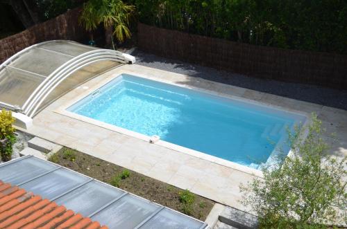 - une vue sur la piscine dans la cour dans l'établissement Maison basque avec piscine, à Lahonce