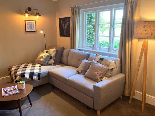 a living room with a couch and a window at Divine, detached countryside cottage near Ludlow. in Ludlow
