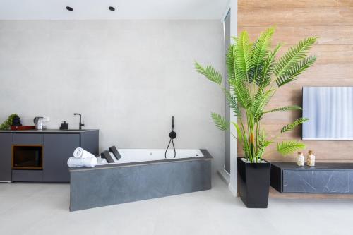 a bathroom with a tub and a plant in it at Alaia Resort- Had Nes אלאיה ריזורט - חד נס in Had Nes