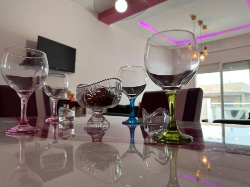 four wine glasses sitting on top of a table at Pink House Martil in Martil