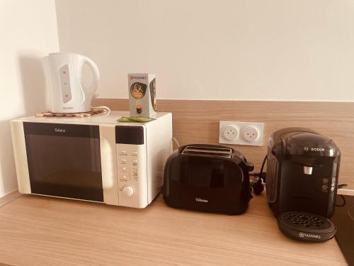 a microwave sitting on a counter with a toaster and a blender at Cocon douillet à Agde in Agde