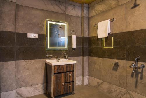 ein Bad mit einem Waschbecken und einem Spiegel in der Unterkunft Wood crista retreat Kufri Open air Terrace in Kūfrī
