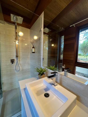 a bathroom with a white sink and a shower at Wandjoo Cottage Cranbourne in Lyndhurst South