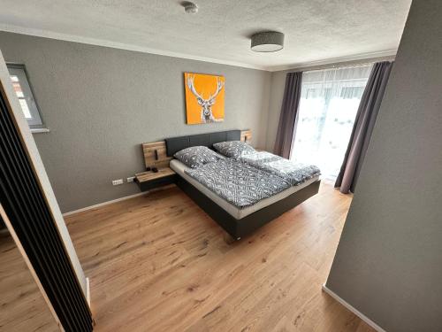 a bedroom with a bed in a room with a window at Ferienwohnungen WahlHeimat-Pfronten in Pfronten