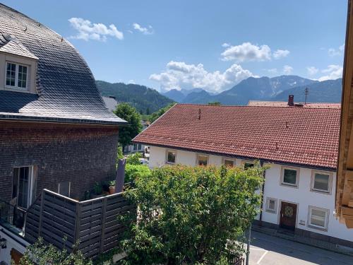 a view of two houses with mountains in the background at Ferienwohnungen WahlHeimat-Pfronten in Pfronten