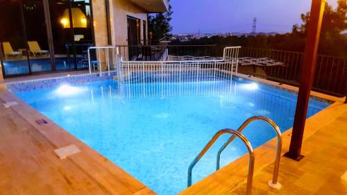 a large swimming pool with blue water at night at Villa15 Lodge, Five-Star Stay 5BD 5-5BA Beach Access Villa with Pool , Gym, Sauna, Alfresco Dining & Garden in Manavgat