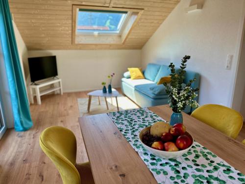 a living room with a table with a bowl of fruit on it at Ferienwohnungen WahlHeimat-Pfronten in Pfronten