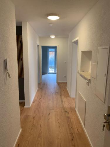 an empty hallway of an apartment with a hard wood floor at Ferienwohnungen WahlHeimat-Pfronten in Pfronten