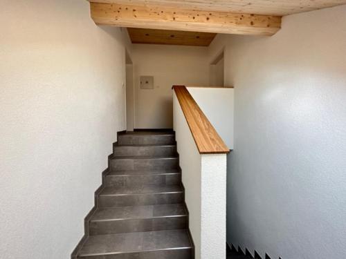 a staircase in a building with a wooden ceiling at Ferienwohnungen WahlHeimat-Pfronten in Pfronten