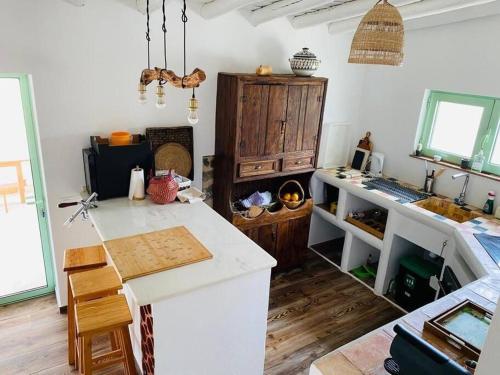 a kitchen with a counter and a stove in a room at Casa na horta, planície alentejana in Simões