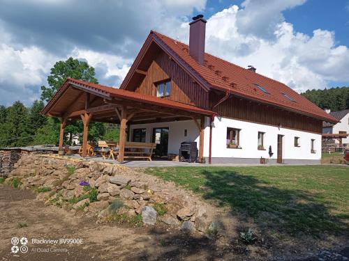 a large white house with a wooden roof at Chalupa Kozí 62 in Klatovy